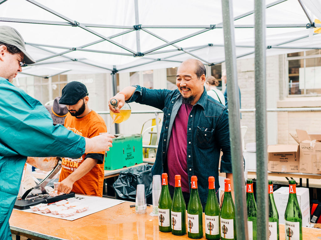 A man pouring cider from a porron at CiderFeast NYC